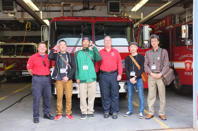 Some of the adult delegation members pose for a group shot with Concord Fire fighters (PHOTO BY JUNKO KARGULA)