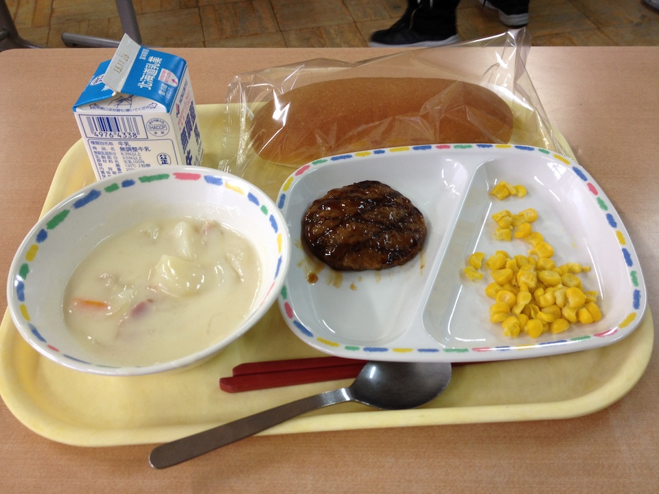 Clam chowder day, accompanied by a hamburger with some teriyaki sauce, corn, and a bread roll